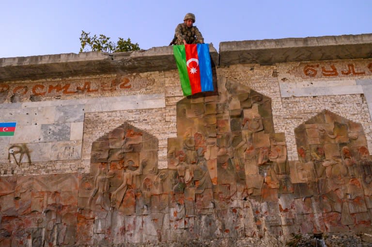 An Azeri soldier hangs the flag of Azerbaijan in Jabrayil