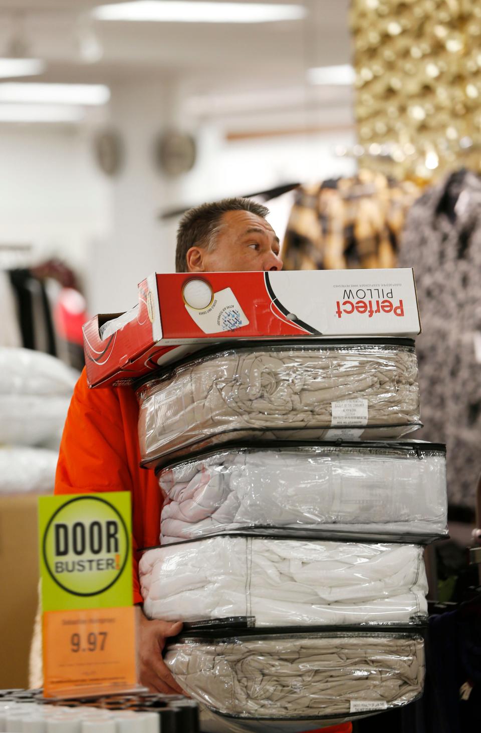 A shopper at Boston Store in the Mayfair mall carries several items on Nov. 2, 2016, during a Black Friday sale.