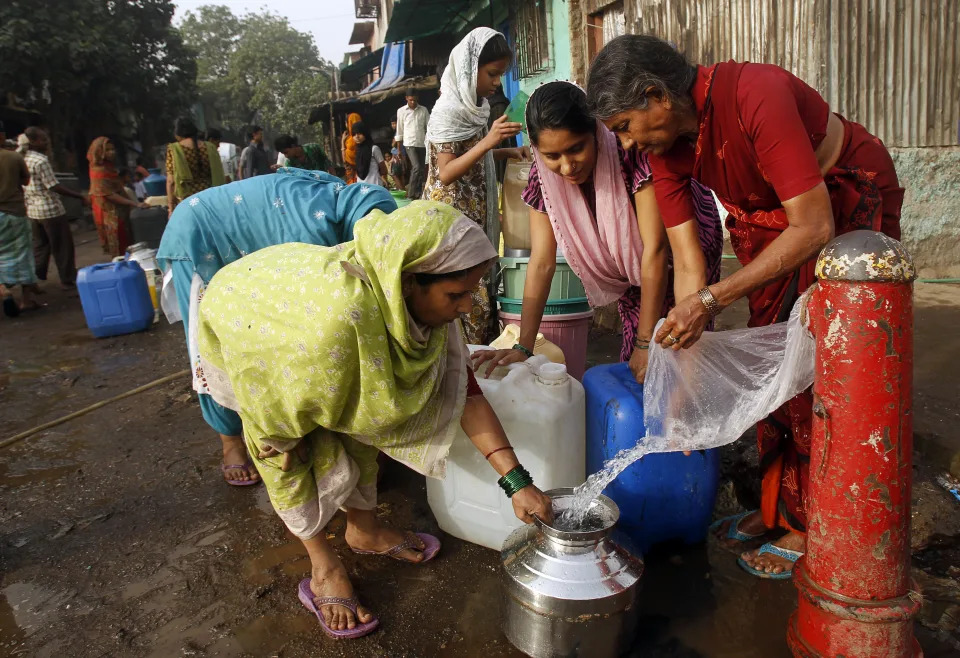 Phụ nữ Ấn Độ lấy nước từ một đường ống bị vỡ trong một khu ổ chuột ở ngoại ô Mumbai, Ấn Độ, Thứ Năm, 22 Tháng Ba, 2012. Liên Hợp Quốc ước tính rằng hơn một phần sáu người trên toàn thế giới không được tiếp cận với 20-50 lít (5-13 gallon) nước ngọt an toàn mỗi ngày để đảm bảo nhu cầu cơ bản của họ để uống, nấu ăn và làm sạch. (Ảnh AP / Rafiq Maqbool)