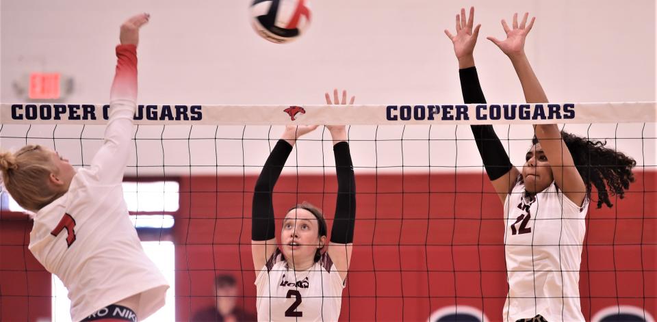 Eastland's Londyn Carroll, left, hits the ball as Brownwood's Aniah Hines (12) and Emma Ringer (2) defend at the net. Brownwood beat Eastland 25-23, 22-25, 27-25 in pool play at the Bev Ball Classic on Friday at Cooper's Cougar Gym.