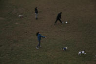 People play with their dogs and a ball at a park in Famagusta gate in central capital Nicosia, Cyprus, Wednesday, Jan. 27, 2021. Cyprus' health minister Constantinos Ioannou said that the first to re-open as of Feb. 1st will be hair and beauty salons followed a week later by retail stores, shopping malls and elementary schools. Students in their final year of high school will also go back to classes on Feb. 8. (AP Photo/Petros Karadjias)