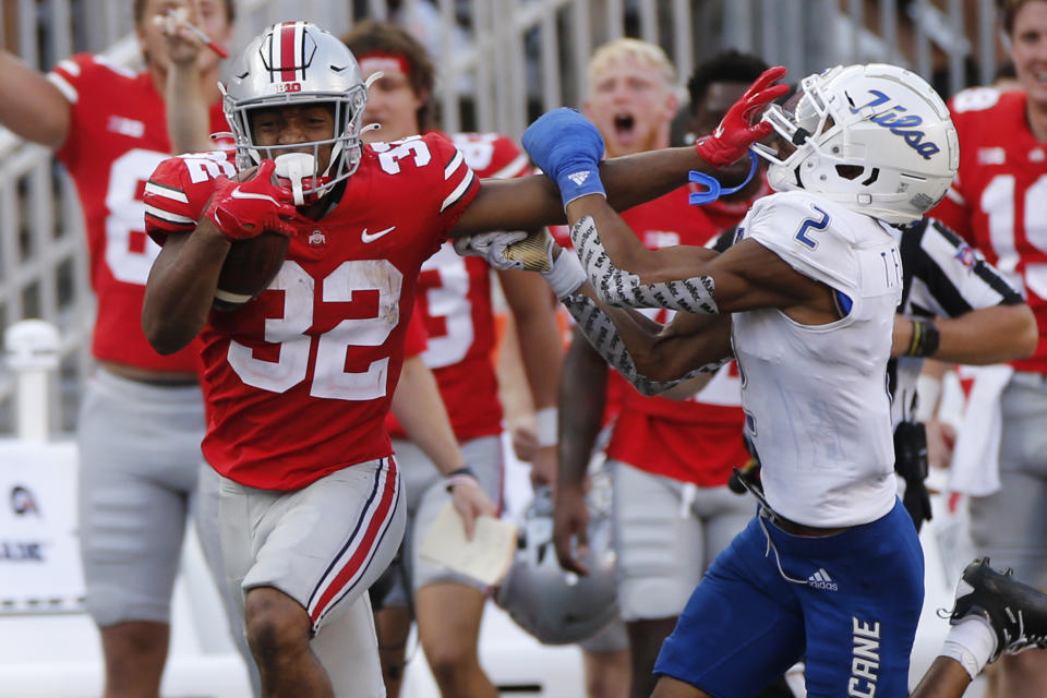 Ohio State running back TreVeyon Henderson, left, stiff-arms Tulsa defensive back Travon Fuller during the second half of an NCAA college football game Saturday, Sept. 18, 2021, in Columbus, Ohio. (AP Photo/Jay LaPrete)