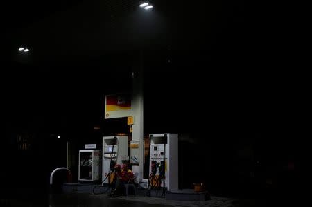 Employees sit next to fuel pumps as they close the petrol station after running out of petrol, in Islamabad, Pakistan July 26, 2017. REUTERS/Caren Firouz