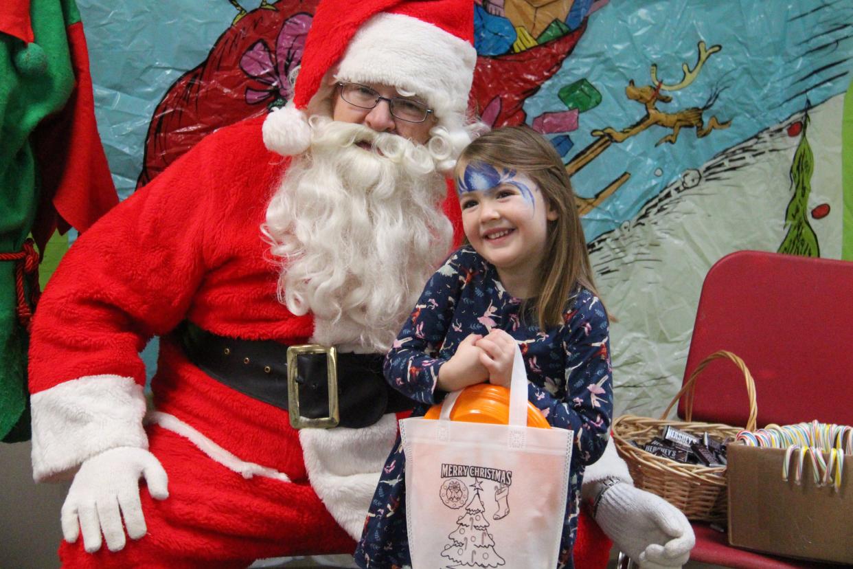 Ellie Kittell, 3 1/2, poses for a photo with Santa during the Community Holiday Party on Saturday, Dec. 3, 2022, at De Soto Intermediate School.