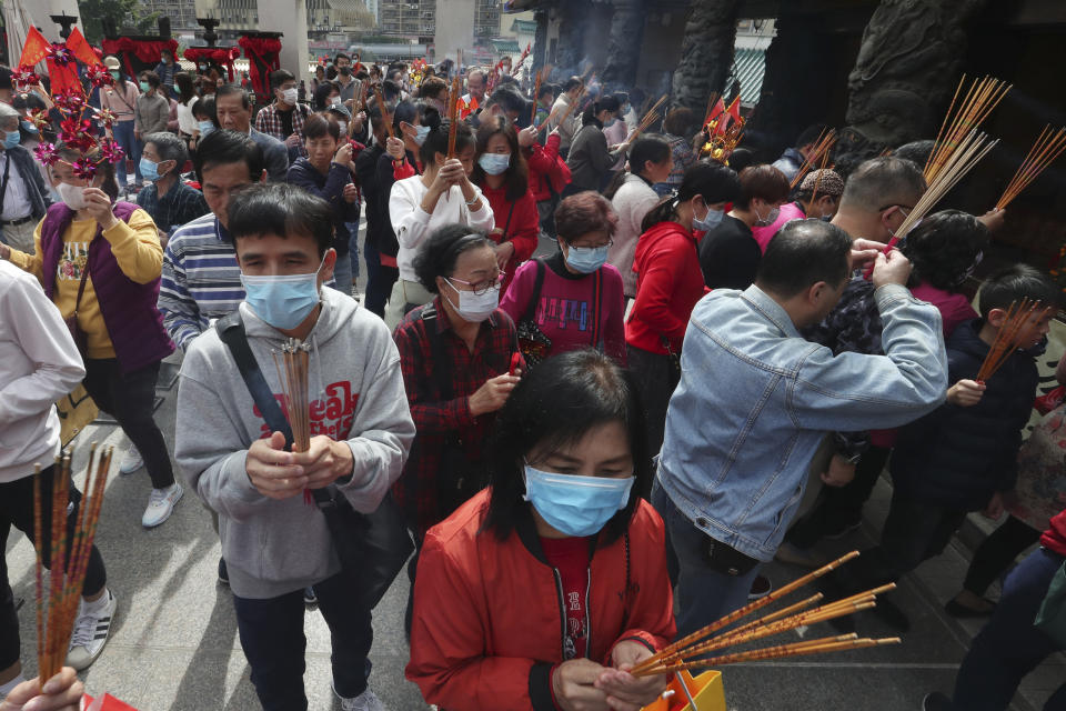 Varias personas queman varitas de incienso mientras rezan en el templo Wong Tai Sin de Hong Kong, el 25 de enero de 2020, para celebrar el inicio del Año Nuevo Lunar, que marca el arranque del Año de la Rata en el horóscopo chino. (AP Foto/Achmad Ibrahim)