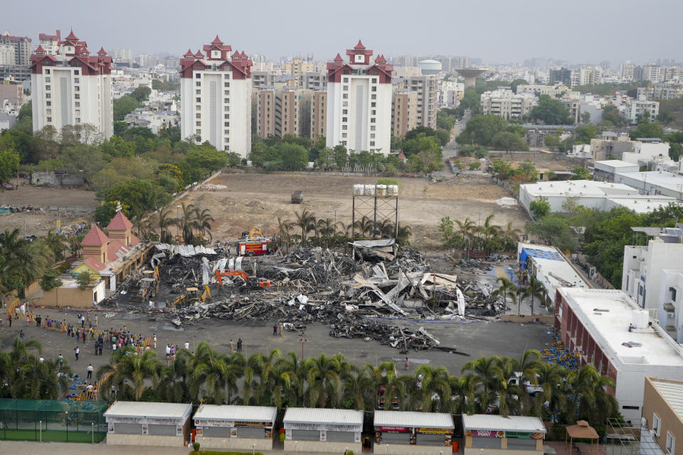 Earthmovers remove burnt debris the day after a fire broke out in an amusement park in Rajkot, India, Sunday, May 26, 2024. A massive fire damaged a large part of the park on Saturday, killing more than twenty people and injuring some others, news reports said. (AP Photo/Ajit Solanki)