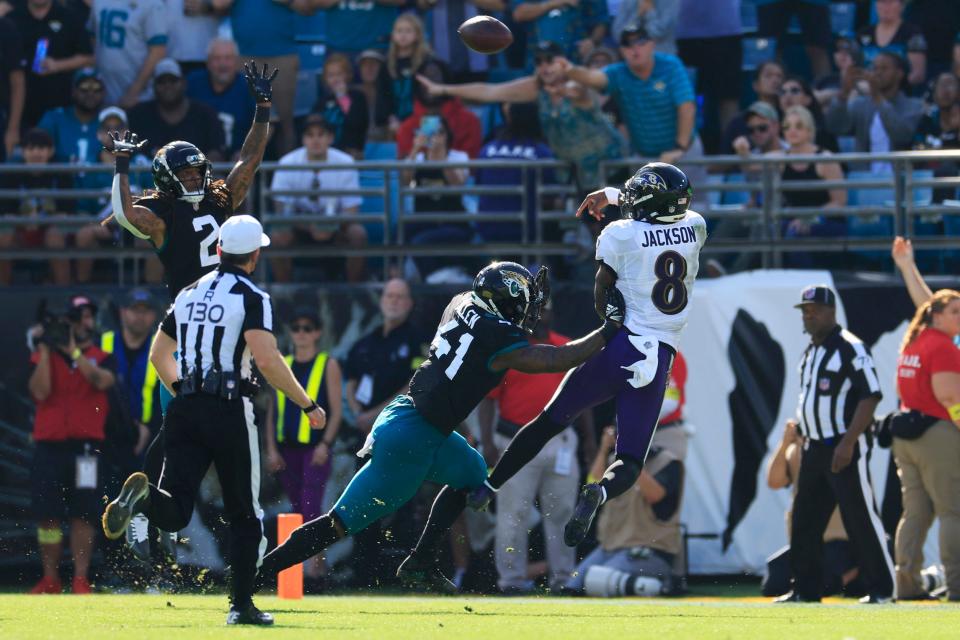 Baltimore Ravens quarterback Lamar Jenkins (8) throws on the run ahead of Jaguars outside linebacker Josh Allen during last year's game in Jacksonville.