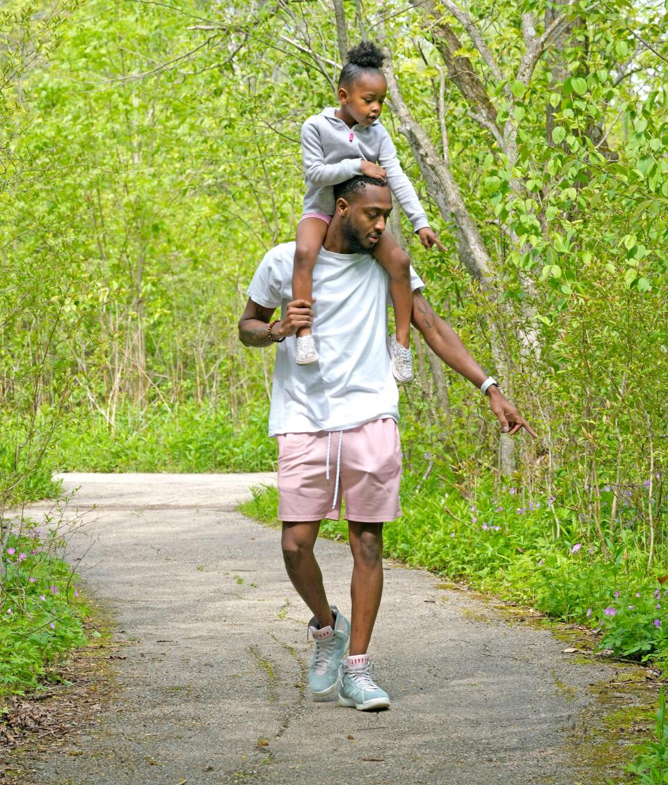 Justin Rutledge and his 5-year-old daughter, Makenzie Rutledge, of Milwaukee, both point out a chipmunk while taking a walk through Schlitz Audubon Nature Center on May 29, 2022.
