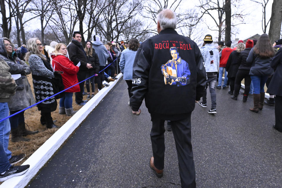 A fan enters Graceland for a memorial service for Lisa Marie Presley Sunday, Jan. 22, 2023, in Memphis, Tenn. She died Jan. 12 after being hospitalized for a medical emergency and was buried on the property next to her son Benjamin Keough, and near her father Elvis Presley and his two parents. (AP Photo/John Amis)