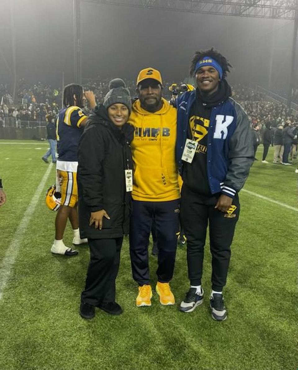 Former Kentucky Wildcats defensive back and current Springfield (Ohio) High School head football coach Maurice Douglass, center, stands with his children, Shiloh, left, and Moses, also an ex-UK football player, right, at this season’s Ohio Division I state championship game on Dec. 1, 2023.