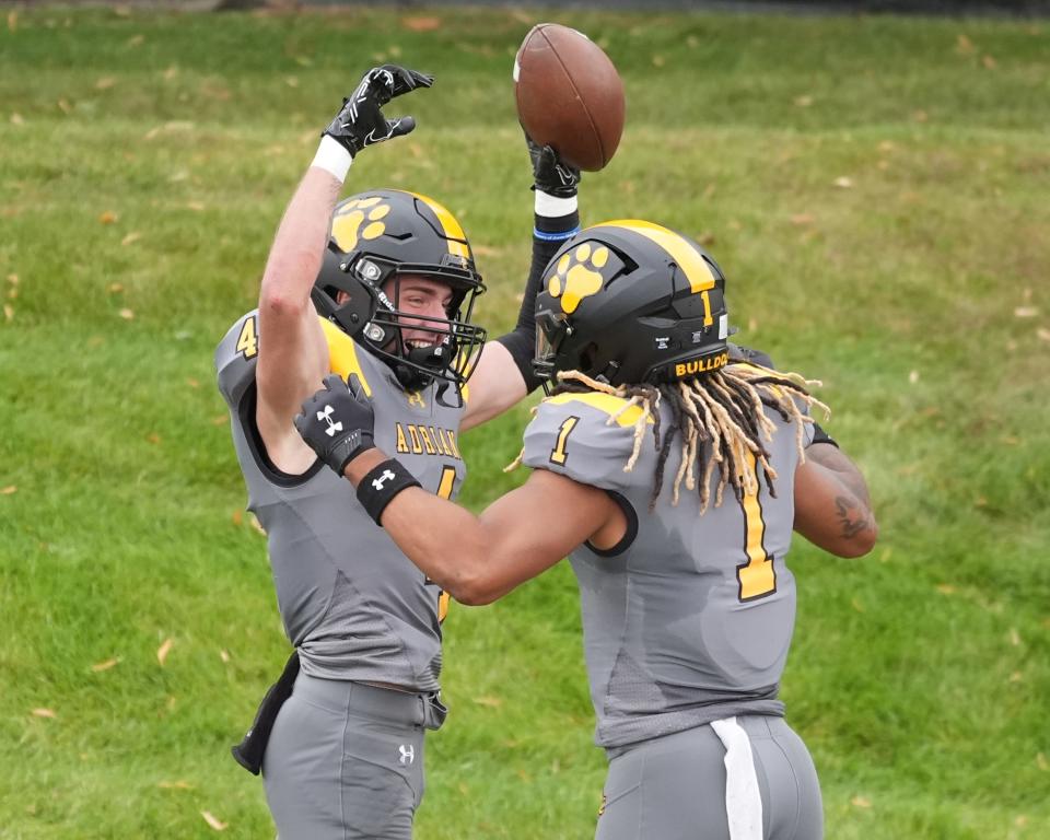 Adrian's Caid Fox (left) and Jalen Wallace celebrate a touchdown during a game against Elmhurst.