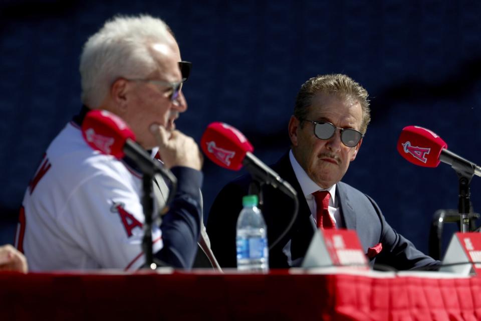 Joe Maddon speaks to reporters as Arte Moreno listens