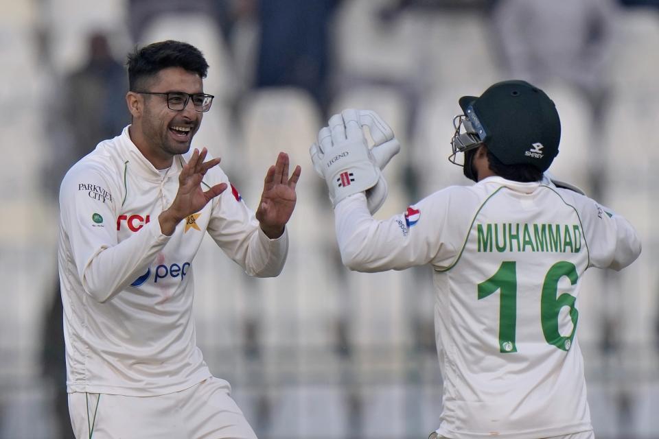 Pakistan's Abrar Ahmed, left, celebrates with teammate after taking the wicket England's Ben Duckett during the second day of the second test cricket match between Pakistan and England, in Multan, Pakistan, Saturday, Dec. 10, 2022. (AP Photo/Anjum Naveed)