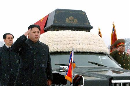 North Korea's new leader Kim Jong-un (2nd L) salutes as he and his uncle Jang Song-thaek (L) accompany the hearse carrying the coffin of late North Korean leader Kim Jong-il during his funeral procession in Pyongyang in this photo taken by Kyodo December 28, 2011. REUTERS/Kyodo