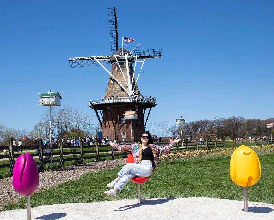 Insider's Gabi Stevenson sitting in a tulip-shaped chair outside a large windmill