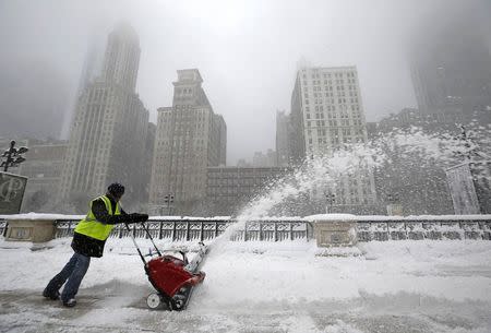 A worker pushes a snow plough to clear a path during blizzard conditions in Chicago, Illinois, February 1, 2015. REUTERS/Jim Young