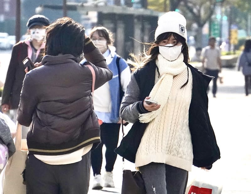 中央氣象署7日表示，這波冷空氣預估8晚至9日清晨最冷，不排除達寒流強度，北部、東北部普遍低溫約攝氏10度。圖為民眾穿厚重外套、圍巾 保暖。（中央社資料照）