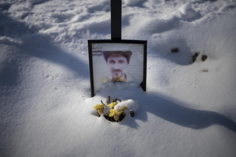 A faded portrait of Sergey Oleksandrovich, 33, sits on his grave at a cemetery in Kyiv, Ukraine, on Thursday, Feb. 9, 2023. He was killed on June 13, 2022. (AP Photo/Emilio Morenatti)