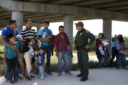 FILE PHOTO: Border patrol agent Sergio Ramirez talks with immigrants who illegally crossed the border from Mexico into the U.S. in the Rio Grande Valley sector, near McAllen, Texas, U.S., April 2, 2018. Picture taken April 2, 2018. REUTERS/Loren Elliott/File Photo