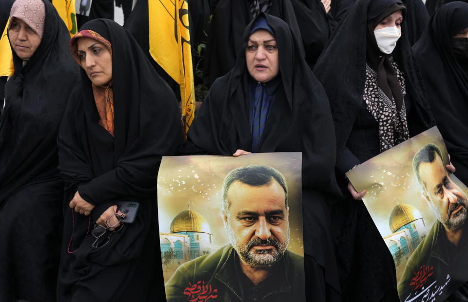 Iranian mourners attend the funeral ceremony of Seyed Razi Mousavi, a high ranking Iranian general of the paramilitary Revolutionary Guard, shown in posters, who was killed in an alleged Israeli airstrike in Syria on Monday, in Tehran, Iran, Thursday, Dec. 28, 2023. (AP Photo/Vahid Salemi)