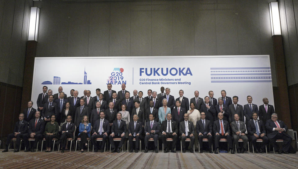 Japan's Finance Minister Taro Aso, center right in front, and Bank of Japan Governor Haruhiko Kuroda, center left in front, pose with other ministers and central bank governors during a family photo session of the G20 meeting Sunday, June 9, 2019, in Fukuoka, western Japan. (AP Photo/Eugene Hoshiko)