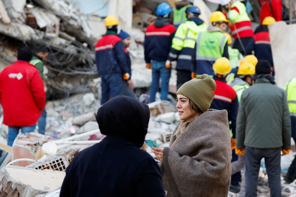 A person reacts as rescuers of International Search and Rescue (ISAR) Germany search for survivors, in the aftermath of a deadly earthquake, in Kirikhan, Turkey (REUTERS)