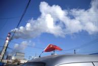 FILE PHOTO: A Chinese flag is seen on the top of a car near a coal-fired power plant in Harbin