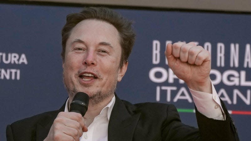 Elon Musk holding his fist in the air