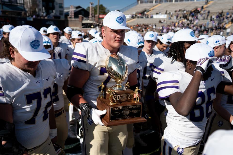 CPA’s John Wayne Oliver (77) holds the team’s trophy after defeating Boyd Buchanan in a Division II-AA championship game at Finley Stadium in Chattanooga, Tenn., Thursday, Nov. 30, 2023.