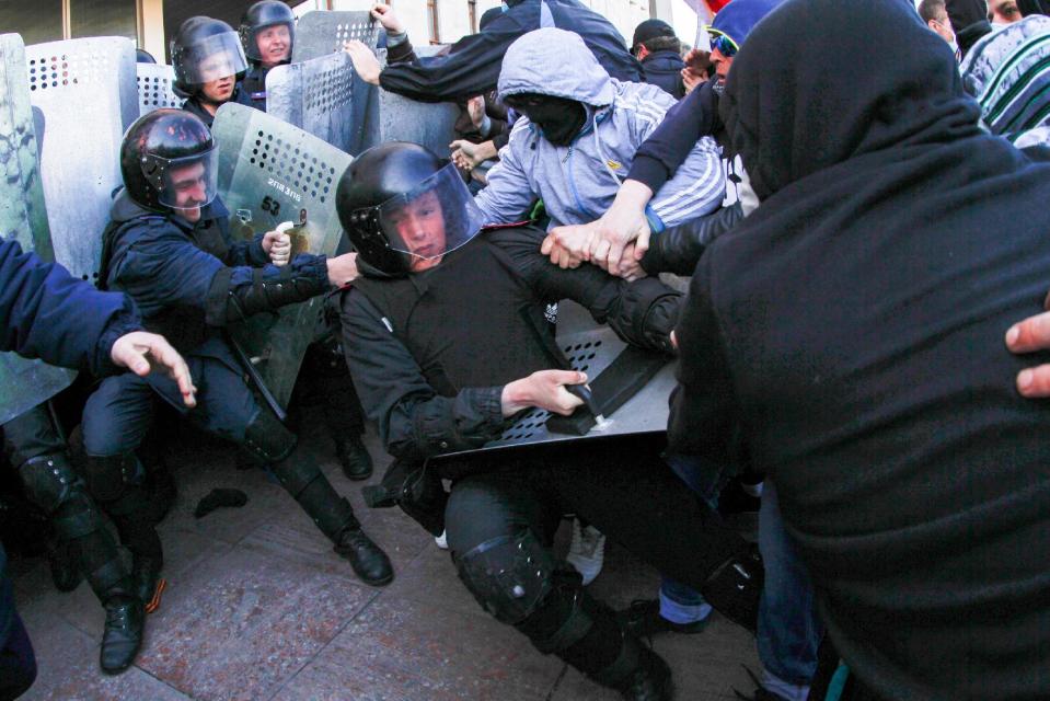 Pro-Russian activists clash with police at the regional administration building in Donetsk, Ukraine, Sunday, April 6, 2014. In Donetsk a large group of people surged into the provincial government building and smashed windows. A gathering of several hundred, many of them waving Russian flags, then listened to speeches delivered from a balcony emblazoned with a banner reading “Donetsk Republic.” (AP Photo/Andrey Basevich)