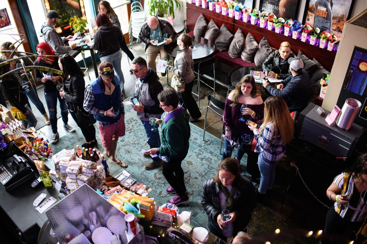 People gather and drink wine at Cameo Art House Theatre during the Fayetteville Art and Wine Walk on Saturday, March 16, 2019, on Hay Street.