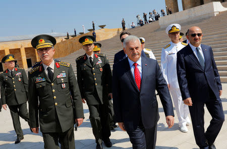 Turkey's Prime Minister Binali Yildirim (C), flanked by Chief of Staff General Hulusi Akar (L), Defense Minister Fikri Isik (R) and the country's top generals, leaves Anitkabir, the mausoleum of modern Turkey's founder Mustafa Kemal Ataturk, after a wreath-laying ceremony ahead of a High Military Council meeting in Ankara, Turkey, July 28, 2016. REUTERS/Umit Bektas