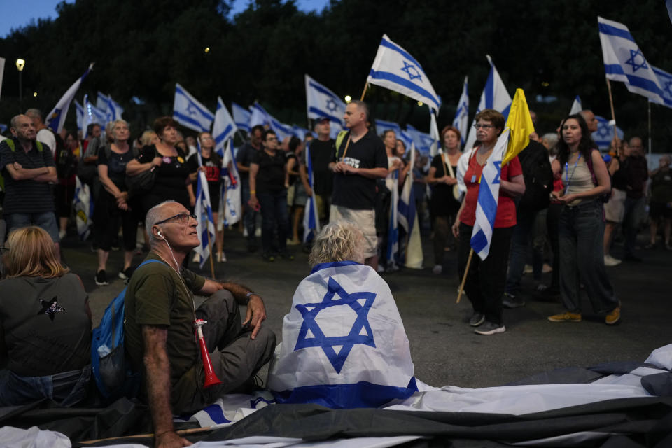 People take part in a protest against Israeli Prime Minister Benjamin Netanyahu's government, demanding new elections and the release of the hostages held in the Gaza Strip by the Hamas militant group, outside of the Knesset, Israel's parliament, in Jerusalem, Monday, June 17, 2024. (AP Photo/Ohad Zwigenberg)