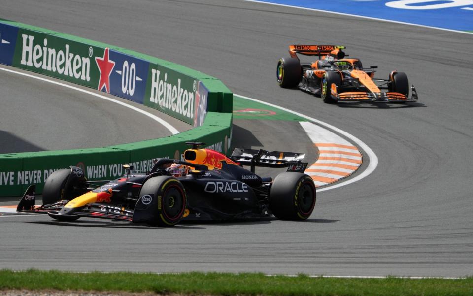 Red Bull driver Max Verstappen of the Netherlands, left, steers his car followed by McLaren driver Lando Norris of Britain during the Formula One Dutch Grand Prix race at the Zandvoort racetrack, Netherlands, Sunday, Aug. 25, 2024.