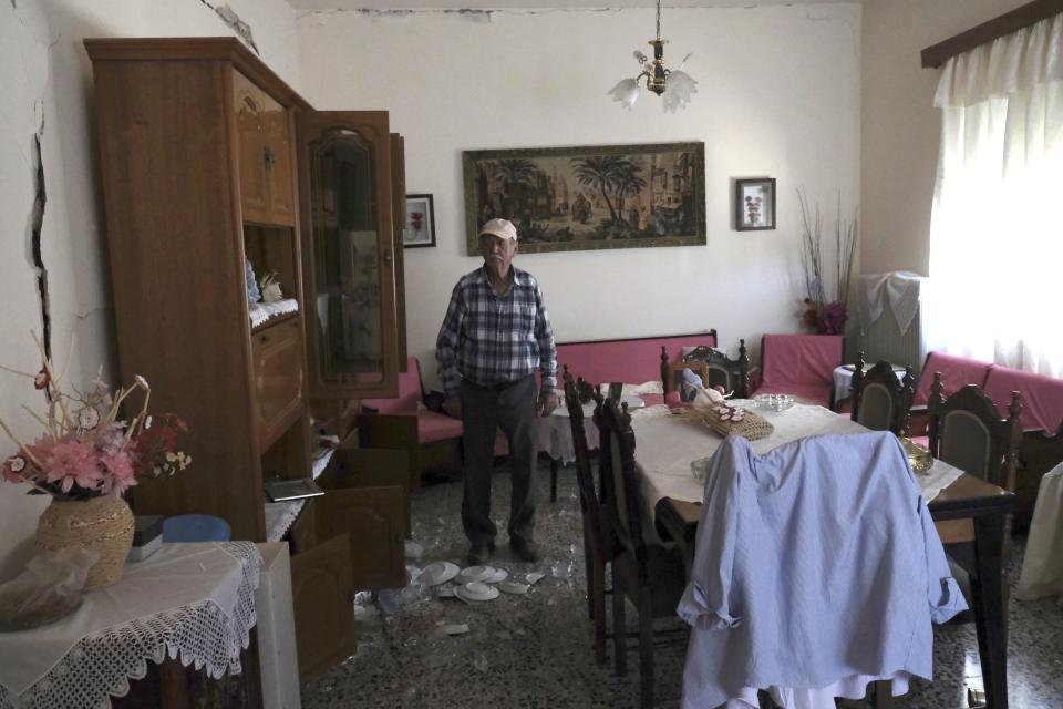 An elderly man stands inside his house after a strong earthquake in Roussochoria village on the southern island of Crete, Greece, Monday, Sept. 27, 2021. A strong earthquake has struck the Greek island of Crete. One person has been killed and at least nine others have been injured. Homes and churches were damaged and rock slides occurred near the country's fourth-largest city.(AP Photo/Harry Nakos)