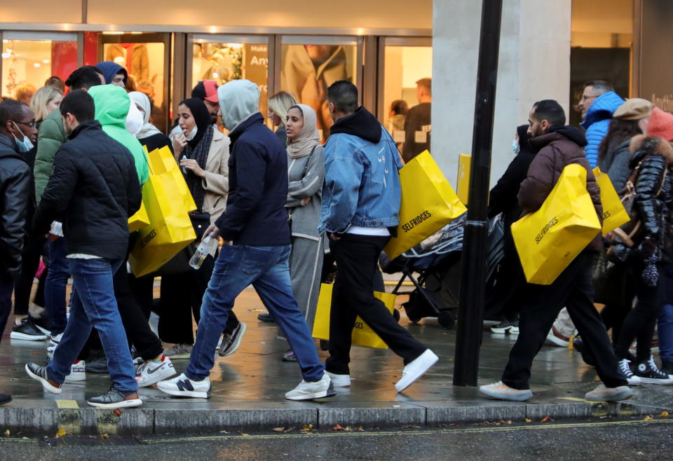 UK retail Pedestrians walk with shopping bags on 