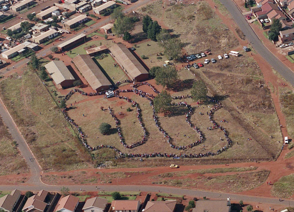 FILE - People queue to cast their votes In Soweto, South Africa April 27, 1994, in the country's first all-race elections. South Africans celebrate "Freedom Day" every April 27, when they remember their country's pivotal first democratic elections in 1994 that announced the official end of the racial segregation and oppression of apartheid. (AP Photo/Denis Farrell. File)