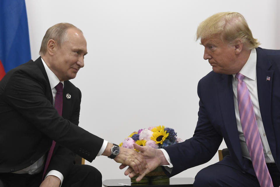 FILE - In this June 28, 2019, file photo President Donald Trump, right, shakes hands with Russian President Vladimir Putin, left, during a bilateral meeting on the sidelines of the G-20 summit in Osaka, Japan. For the past three years, the administration has careered between President Donald Trump's attempts to curry favor and friendship with Vladimir Putin and longstanding deep-seated concerns about Putin's intentions. (AP Photo/Susan Walsh, File)