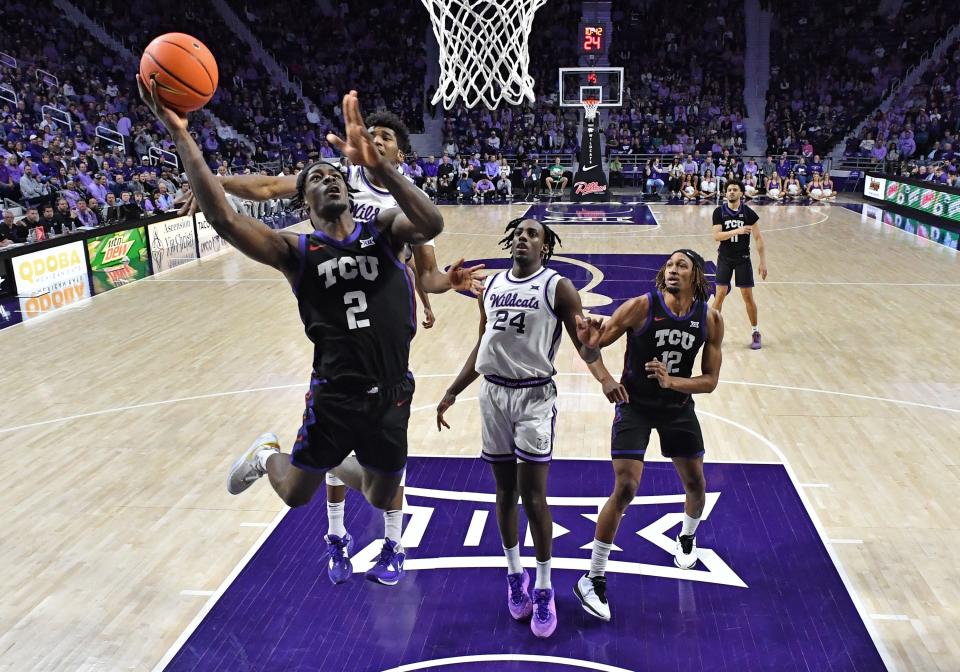 MANHATTAN, KS - FEBRUARY 17: Emanuel Miller #2 of the TCU Horned Frogs drives into the basket past Arthur Kaluma #24 of the Kansas State Wildcats in the second half at Bramlage Coliseum on February 17, 2024 in Manhattan, Kansas. (Photo by Peter Aiken/Getty Images)