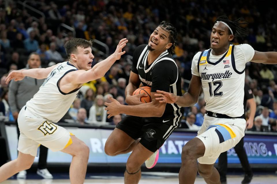 Providence's Bryce Hopkins tries to drive between Marquette's Tyler Kolek, left, and Olivier-Maxence Prosper during the second half of an NCAA college basketball game Wednesday, Jan. 18, 2023, in Milwaukee. Marquette won 83-75. (AP Photo/Morry Gash)