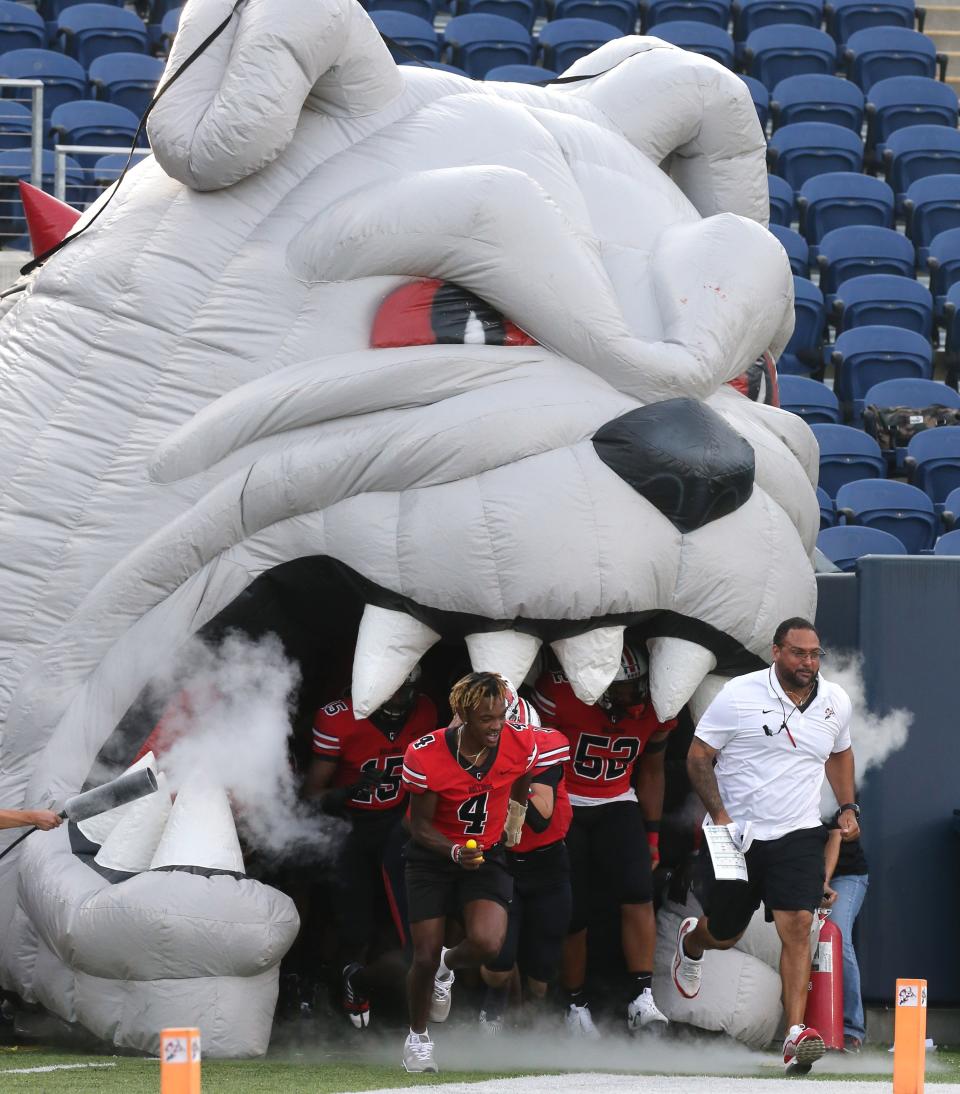 McKinley head coach Antonio Hall takes the field with his Bulldogs prior to their game against Dublin Coffman at Canton in September.