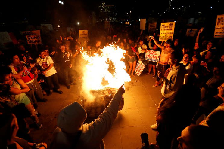 A Donald Trump piñata is burned in Los Angeles on Nov. 9, 2016, by people protesting his election as president. (Photo: Mario Anzuoni/Reuters)