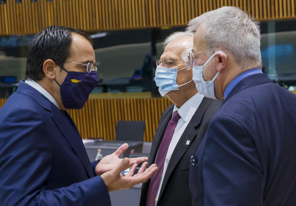 Cypriot Foreign Minister Nicos Christodoulides, left, speaks with European Union foreign policy chief Josep Borrell, second right, during a meeting of European Union foreign ministers at the European Council building in Luxembourg, Monday, Oct. 12, 2020. European Union foreign ministers were weighing Monday whether to impose sanctions on Russian officials and organizations blamed for the poisoning of opposition leader Alexei Navalny with a Soviet-era nerve agent. (Jean-Christophe Verhaegen, Pool via AP)