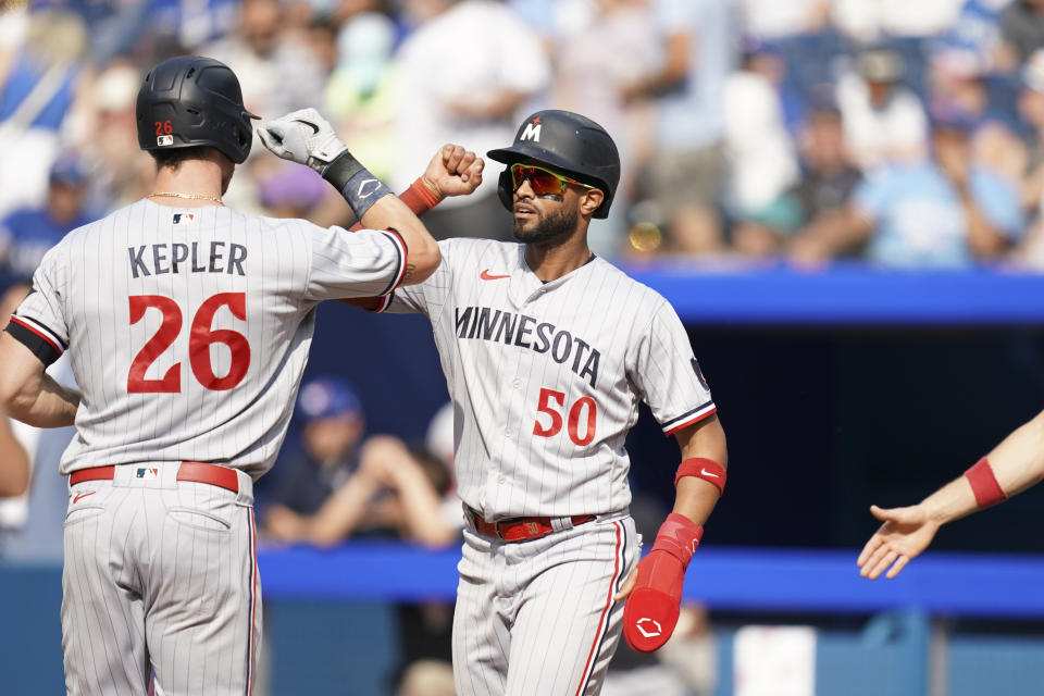 Minnesota Twins' Max Kepler (26) celebrates his three-run home run against the Toronto Blue Jays with Willi Castro (50) during the eighth inning of a baseball game, Saturday, June 10, 2023, in Toronto. (Arlyn McAdorey/The Canadian Press via AP)