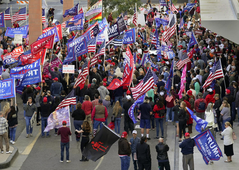 Supporters of President Donald Trump protest in front of a local hotel where Arizona Republicans have scheduled a meeting as a "fact-finding hearing" to discuss the election, featuring members of Trump's legal team and Arizona legislators, Monday, Nov. 30, 2020, in Phoenix. (AP Photo/Ross D. Franklin)