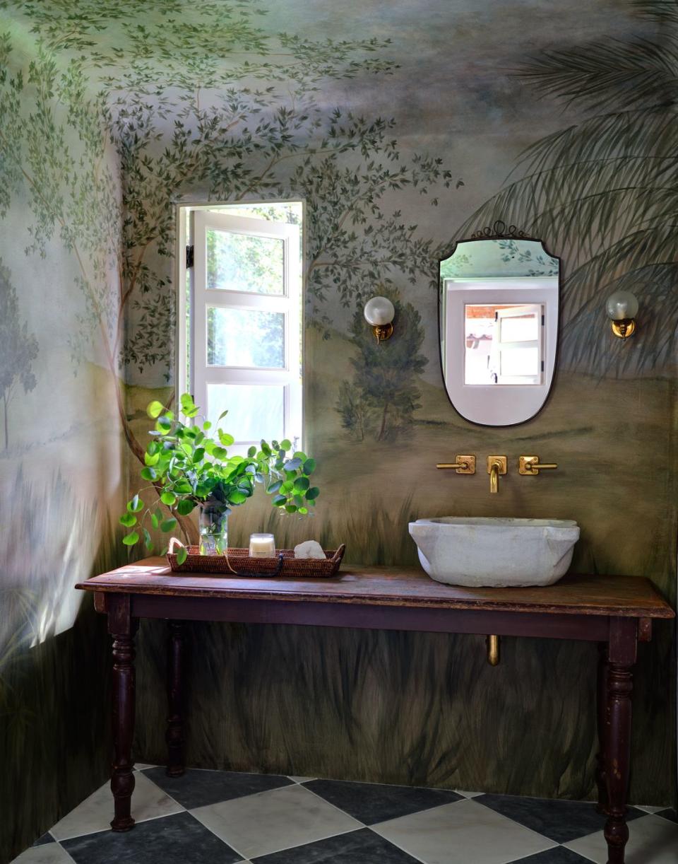 <p>Sure, it helps, but you don't need a casement window to bring the outdoors into your bathroom. This vanity has a museum-like appeal with its landscape background, sconces worn like earrings, and a simple repurposed wooden console.</p>