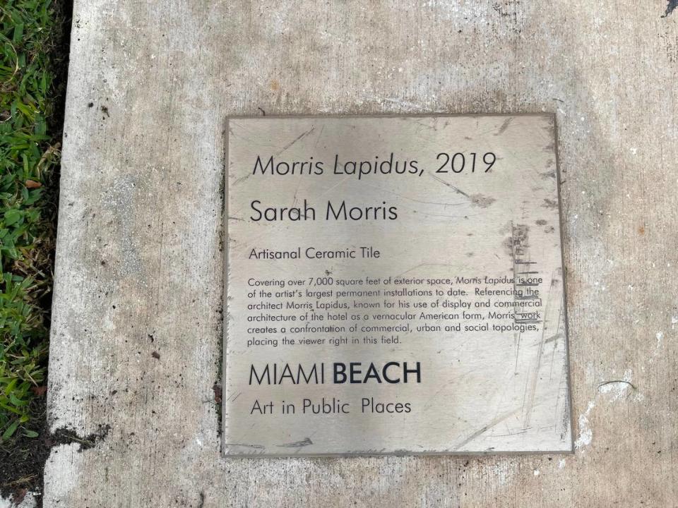 The plaque for “Morris Lapidus,” an artwork by Sarah Morris, remains on the sidewalk in front of the east wall of the Miami Beach Convention Center. The artwork on the east wall was in such poor condition, the city installed a protective covering over it.