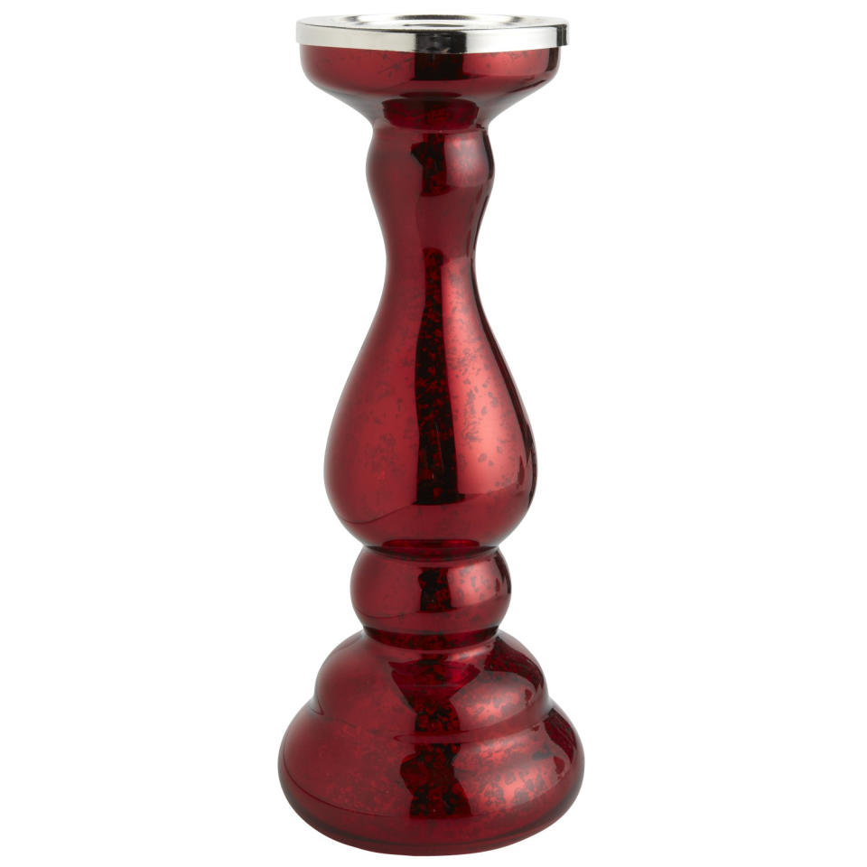 In this photo provided by Pier 1 Imports, a red mercury glass pillar stand candle holder adds sparkle and shine even without lit candles from Pier1.com. Red is once again a popular color this holiday season, after a few years where it was less so. Following the general trend in home decor, holiday trim and accessories this year are a mix of eclectic and traditional colors and styles. (AP Photo/Pier 1 Imports)