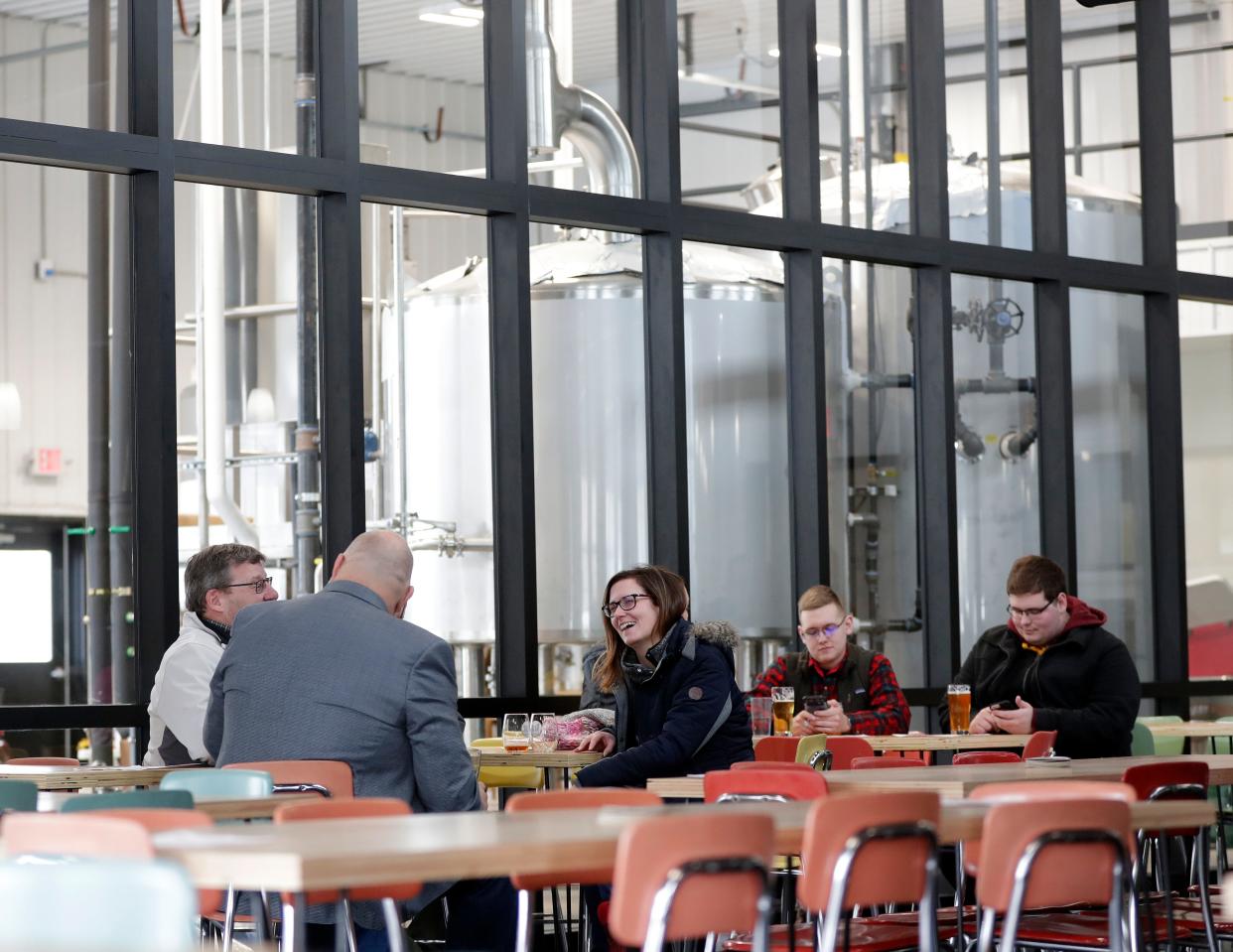 Patrons chat with each other during the Feb. 8. 2020, grand opening of Zambaldi Beer in Allouez.