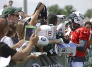 New York Jets quarterback Michael Vick (1) signs autographs for fans after practice during an NFL football training camp on Saturday, July 26, 2014, in Cortland, N.Y. (AP Photo/Frank Franklin II)